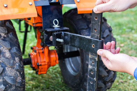Adjustment of the coupling and attachments in a multifunctional motor cultivator for cottages.の写真素材