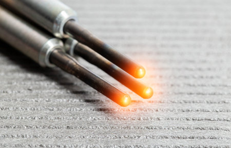 Serviceable modern ceramic glow plugs on a gray background. Orange glow, heating element....