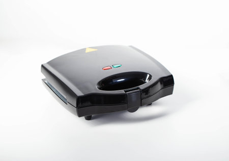 Black modern sandwich maker on a white background, isolate, close-up. Making toast and sandwiches,...