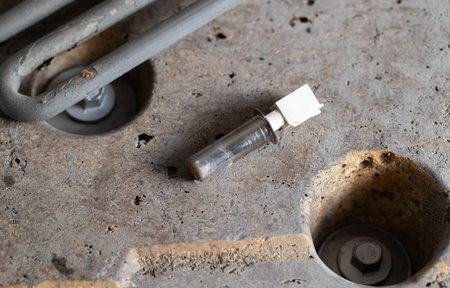 The electric heating element and temperature sensor, thermostat are on the disassembled washing machine. The concept of replacing and repairing spare parts in a washing machine. Scale and hard water, industryの写真素材