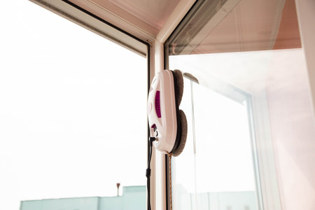 Automatic vacuum robot window washer washes glass from dirt. Modern technology and security.の写真素材