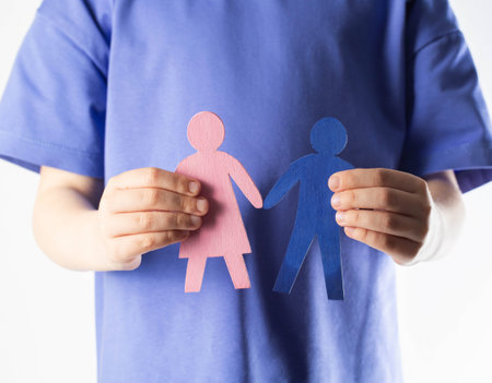 The girl holds figurines of her mother and father in her hands. Orphans concept. Adoption of children from an orphanage, close-upの写真素材