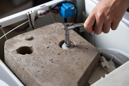 Twisting of the counterweight stone in the washing machine due to vibration and noise during the spin cycle.の写真素材