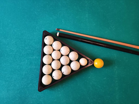 Balls with a cue lie on the green cloth of a billiard table, background.の写真素材