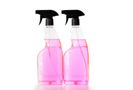Two spray bottles with pink liquid on a white background, close-up.の写真素材