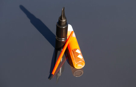 A can of black paint, rust converter and a brush on the hood of a car. Concept for removing chips from paintwork on a car, close-upの写真素材