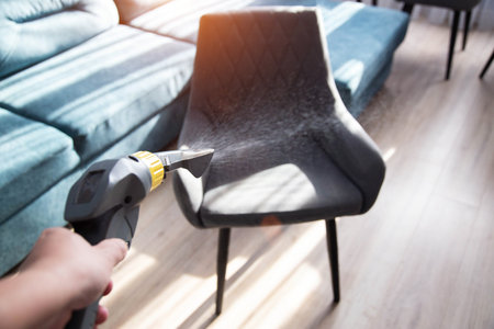 Dry cleaning services, washing and cleaning gray fabric chairs with a washing vacuum cleaner.の写真素材