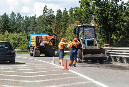 Workers on the road lay asphalt against the background of road equipment on the highway, industry. Copy space for text, forestの写真素材