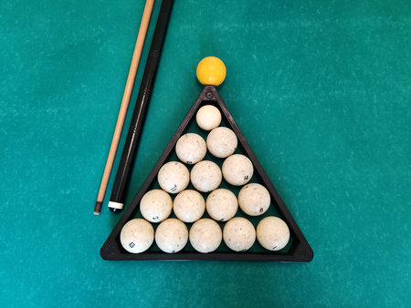 Balls with a cue lie on the green cloth of a billiard table, background.の写真素材