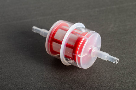 Transparent automotive fine fuel filter on a gray background