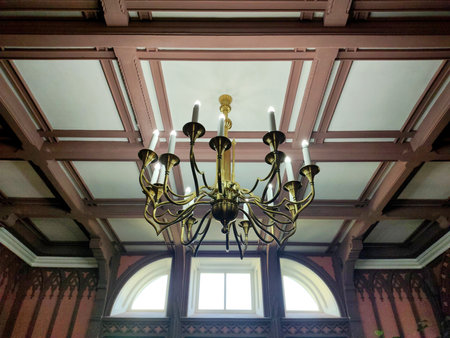 Antique chandeliers in a museum with a ceiling and walls in patterns against the background of a window.の写真素材