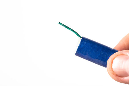 Firecracker with a wick in hand on a white background, isolate. Copy space for text