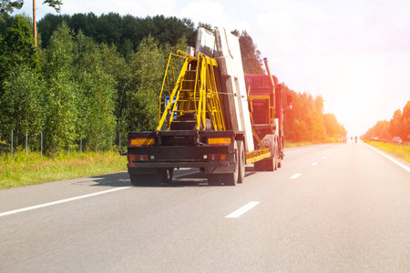 A panel truck with a semi-trailer transports reinforced concrete slabs for building a house. Cargo...