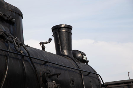 Chimney of a steam locomotive with a spotlight against the sky, an exhibition of old locomotivesの写真素材