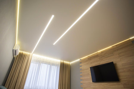 Beautiful designer stylish stretch ceiling with LED light lines against the background of a window with curtains in the living room. Option for lighting with light lines, suspendedの写真素材
