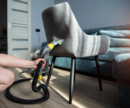 Washing and cleaning a gray chair with fabric upholstery using a washing vacuum cleaner and cleaning agent. Cleaning services. Copy space for textの写真素材