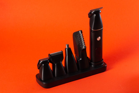 Modern set of hair trimmer with different attachments on a red background. Copy space for textの写真素材