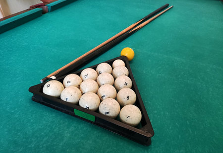 Balls with a cue lie on the green cloth of a billiard table, background.の写真素材