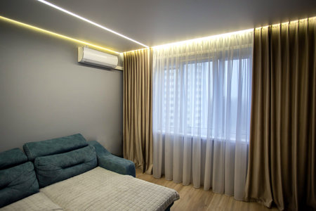 Window in a hall room with brown curtains and an air conditioner on the wall. Modern renovation. Copy space for textの写真素材