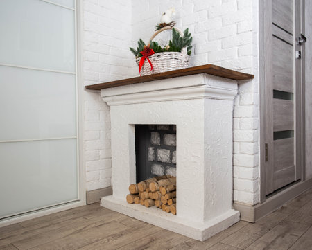 Handmade fireplace with logs and Christmas basket on top, close-up.の写真素材