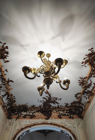 Beautiful ancient copper chandelier on the ceiling with patterns in the museumの写真素材