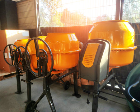 Sale of yellow concrete mixers in a store against the backdrop of a window with a sunset, indoorsの写真素材