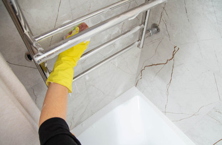 Washing and cleaning the heated towel rail in the bathroom. Copy space for textの写真素材