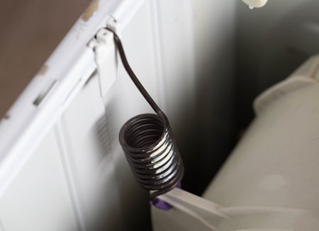 suspension spring of the washing machine tank to dampen vibration when spinning the washing machine. Breakdown and replacement of spare parts, close-upの写真素材