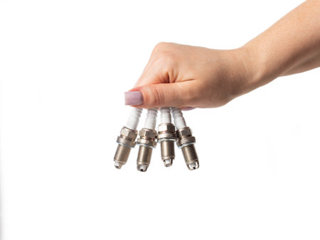Car spark plugs in a girl's hand on a white background, isolate.の写真素材