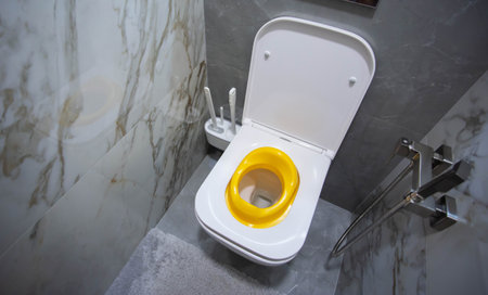 Yellow child toilet seat for children in the toilet. Convenience and comfort for the child on the toilet.の写真素材