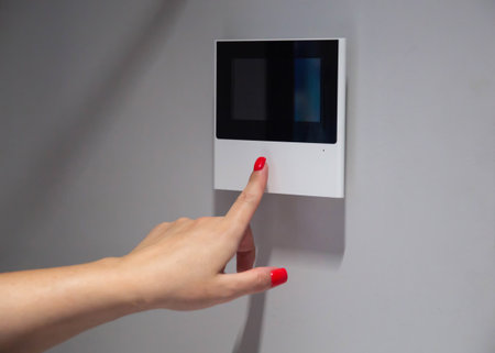 A woman's hand with a red manicure opens the front door in an electronic video intercom, close-up. Copy space for text, automationの写真素材