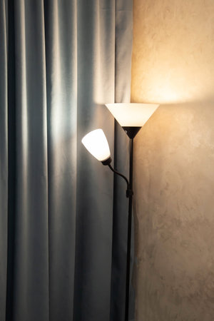 Beautiful modern floor lamp light fixture against turquoise curtain in roomの写真素材