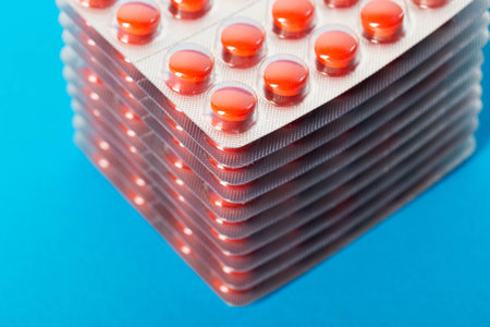Stack of red pills on blue background for hangoverの写真素材