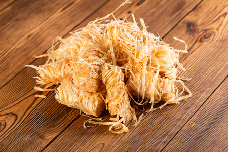 Wooden rolls for starting a fire, stove, or barbecue, soaked in paraffin, on a wooden background