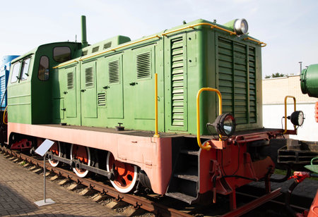 A vintage green locomotive stands on display at a railway museum. The train features colorful...