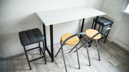 A compact table with stylish black upholstered chairs and stools in the kitchen