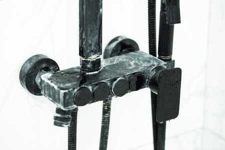 White scale from hard water on black bathroom faucetsの写真素材
