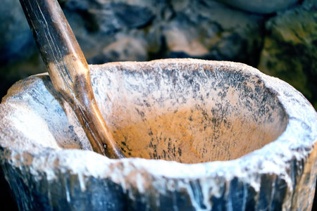 An old mortar with a wooden handle for grinding flourの写真素材