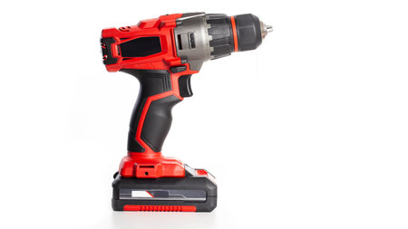 Modern red drill-screwdriver on a white background. Tool for work in industry.