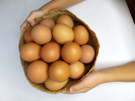 Eggs in a basket in the hands of a child.の写真素材