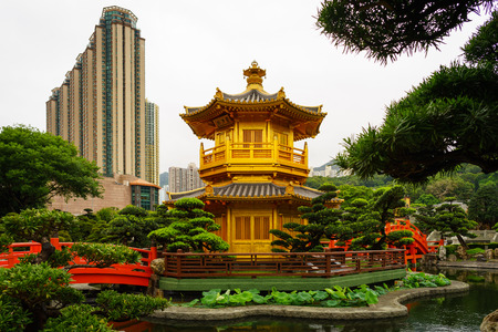 Chi Lin Nunnery - Diamond Hill, Hong Kong April 27 2017: Traditional golden pagoda in middle of garden with skyscraper at backのeditorial素材