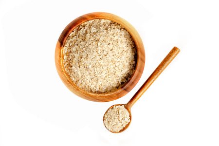 Oatmeal in wooden bowl and white backgroundの写真素材