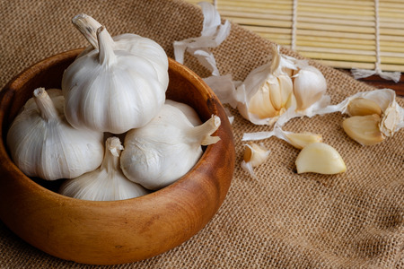 Garlic cloves and bulb in wooden bowlの写真素材