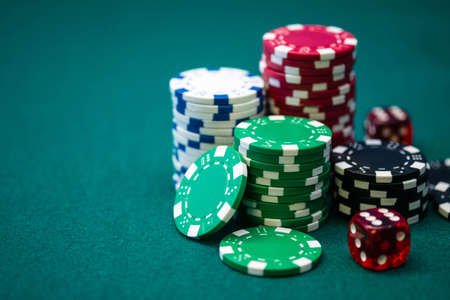 Stack of poker chips and dice on casino table
