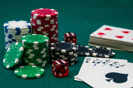 Poker chips, dice and Royal Flush card combination on green tableの写真素材