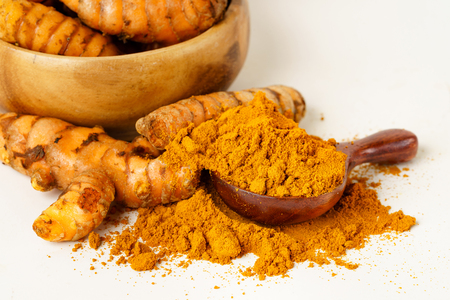 Turmeric whole and powder on white isolated color backgroundの写真素材
