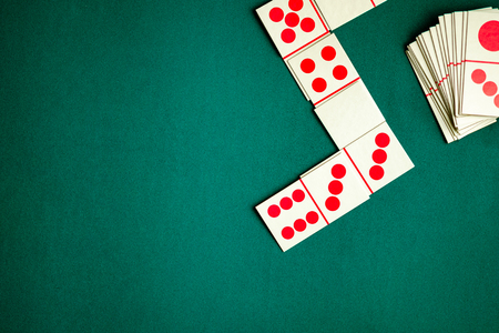 Dominoes playing card on green color table