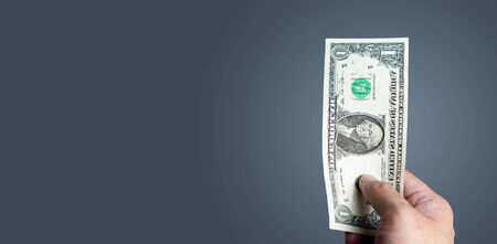 Young man holding small dollar bill