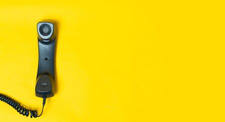 Landline telephone device on yellow background. Communication technology or customer support conceptの写真素材