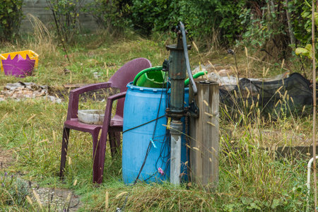 A bucket of water and a pump on the street in the villageの写真素材